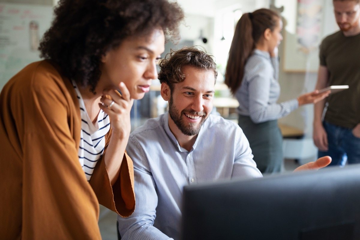 Colleagues working together at a laptop in an office