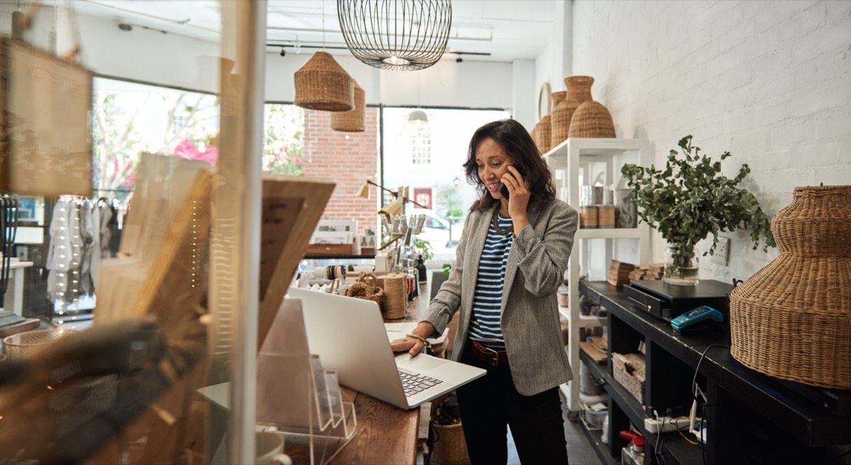 Small business owner using a laptop in a retail shop
